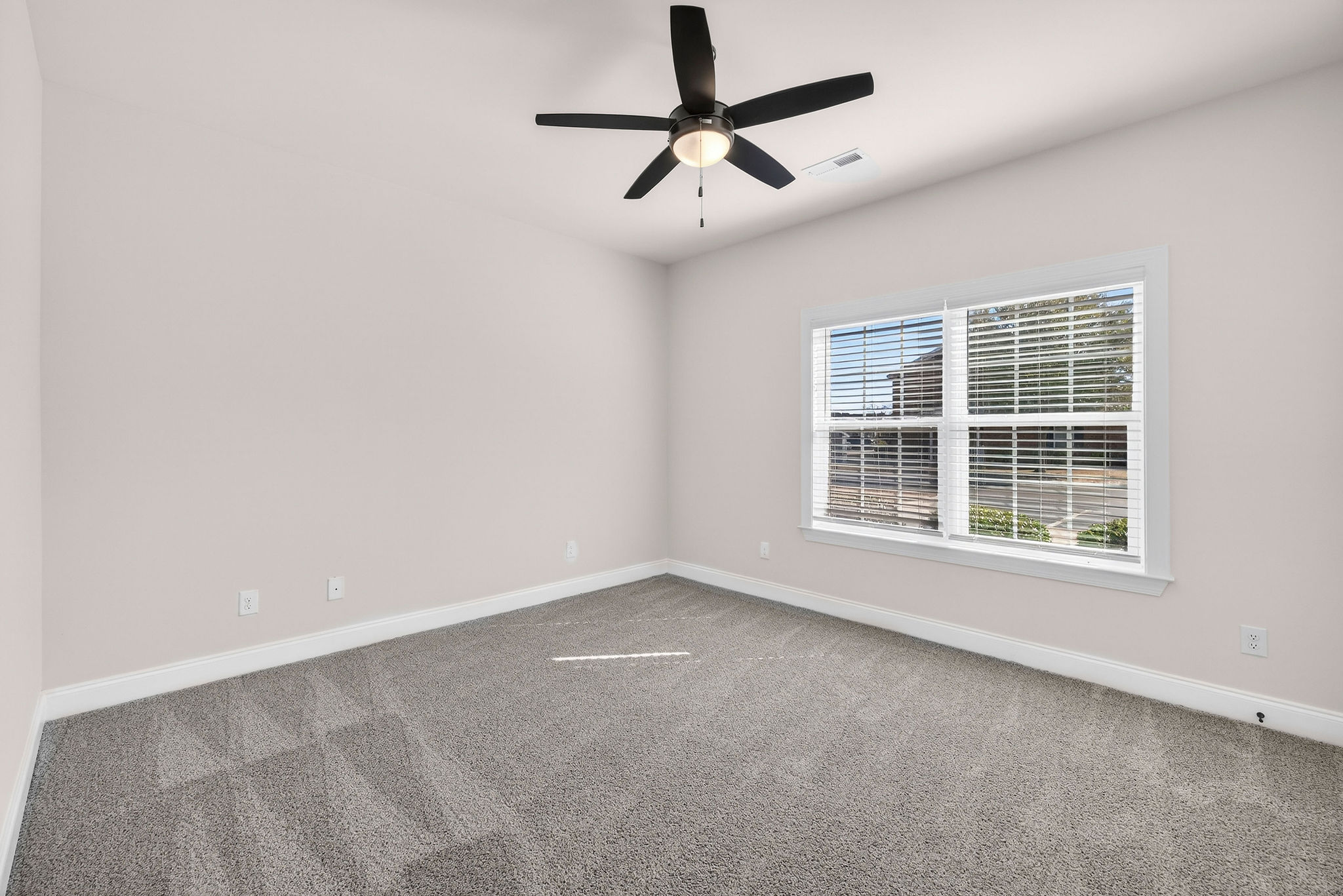 Spacious bedrooms with plush carpeting and ceiling fan