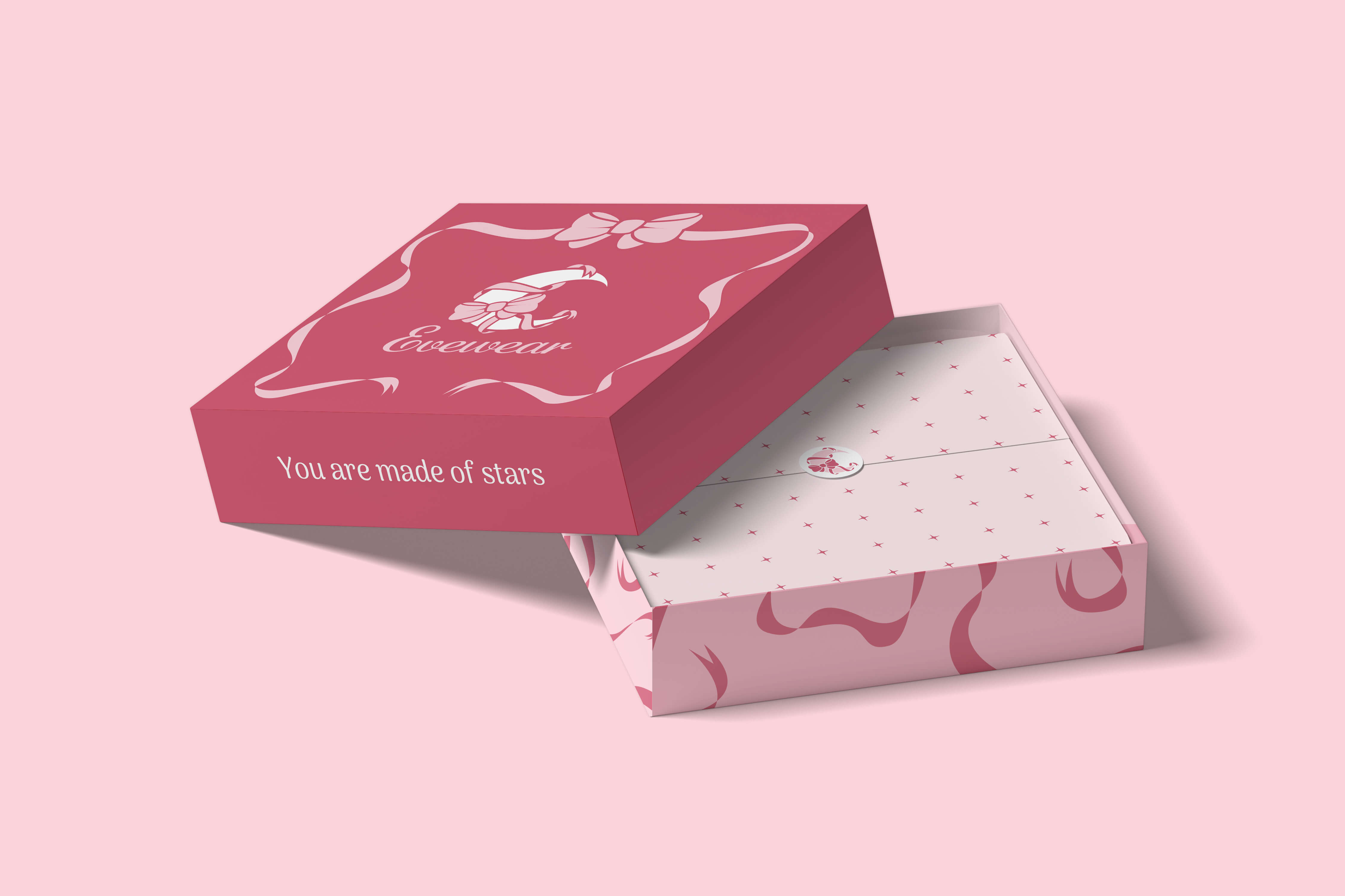 Pink and red decorative gift box with the lid partially open, featuring a floral ribbon design and the text 'You are made of stars.'