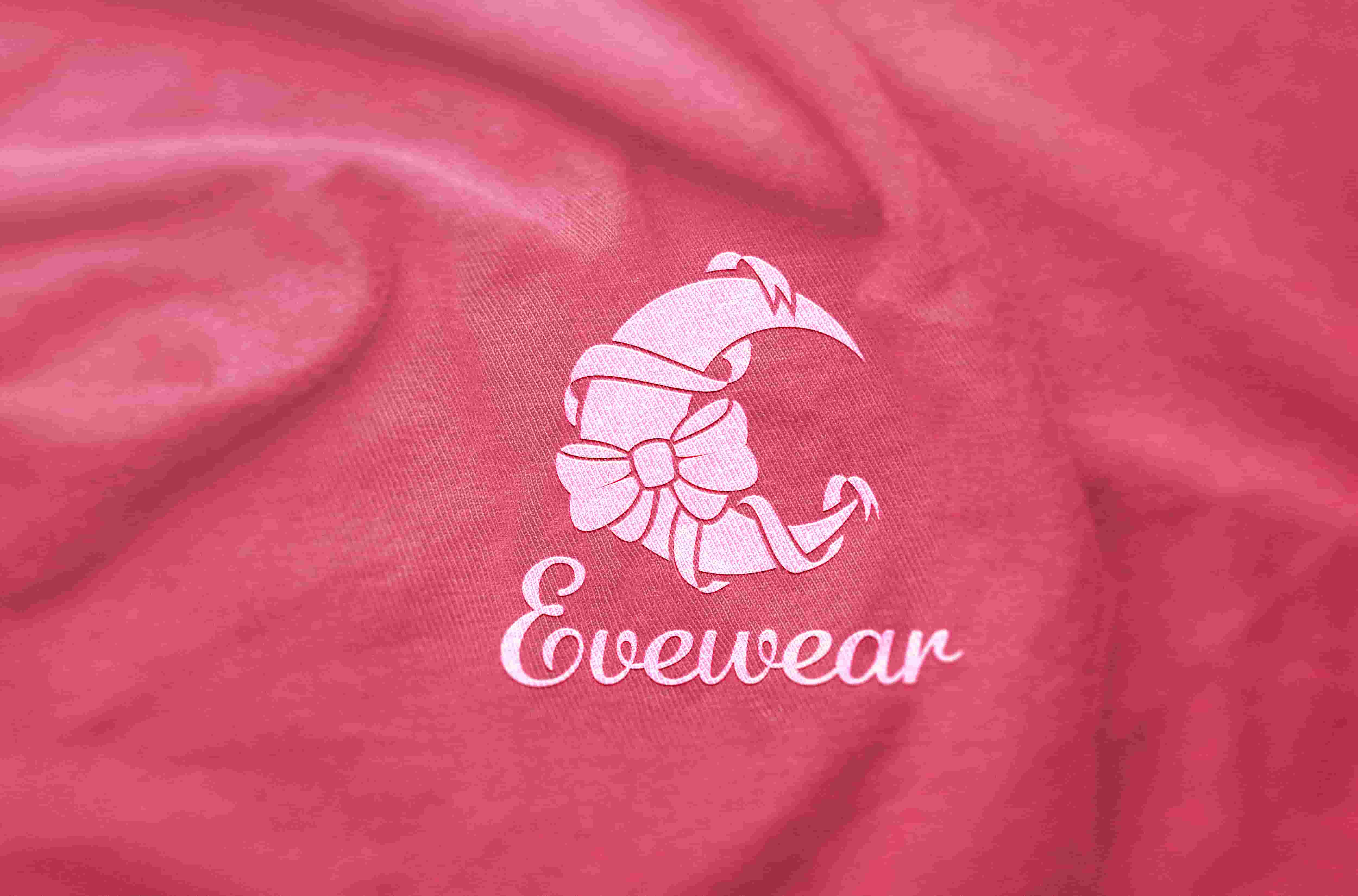 Pink fabric with a white logo featuring a stylized crescent moon decorated with a bow and the word 'Evewear' beneath it.