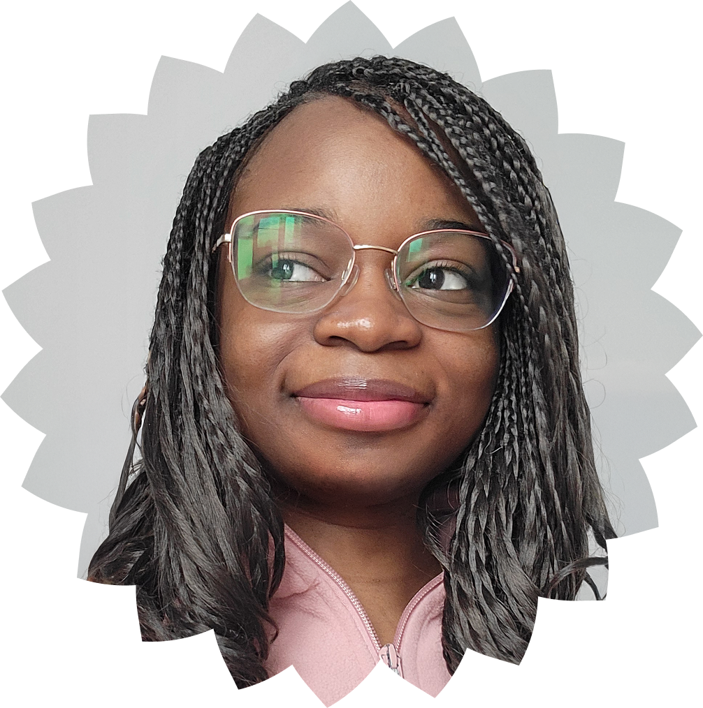 Woman with braided hair, wearing glasses and a pink zip-up jacket, smiling and looking to the side.