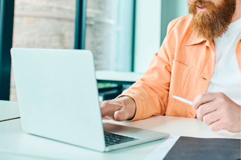 Ein Mann der an einem Laptop sitzt.