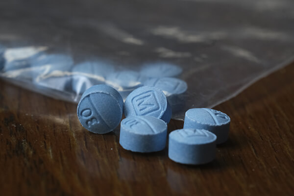 Blue pills and baggie on table