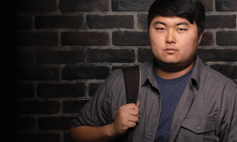 Serious young man with backpack on his shoulder