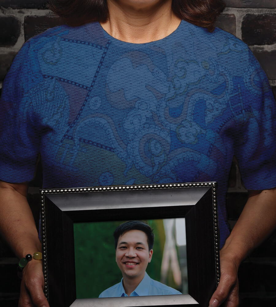 Closeup of woman holding framed photo of her son