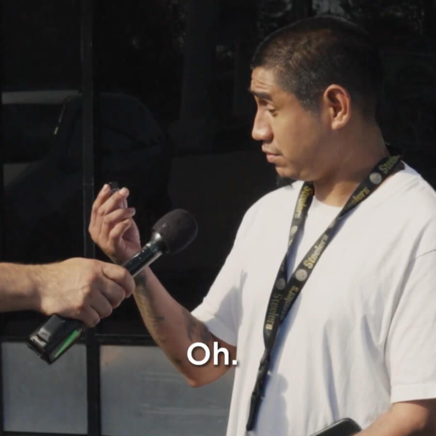 Man holding vial talking to host with microphone