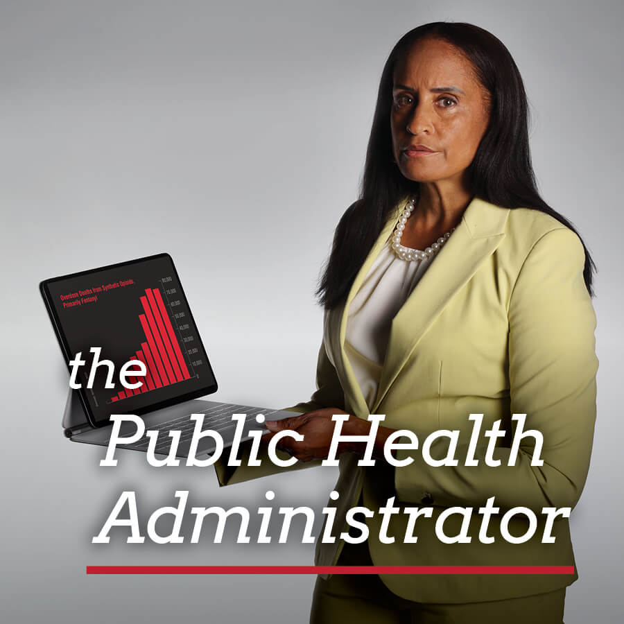 A woman in professional clothing holding up a laptop with a chart on it