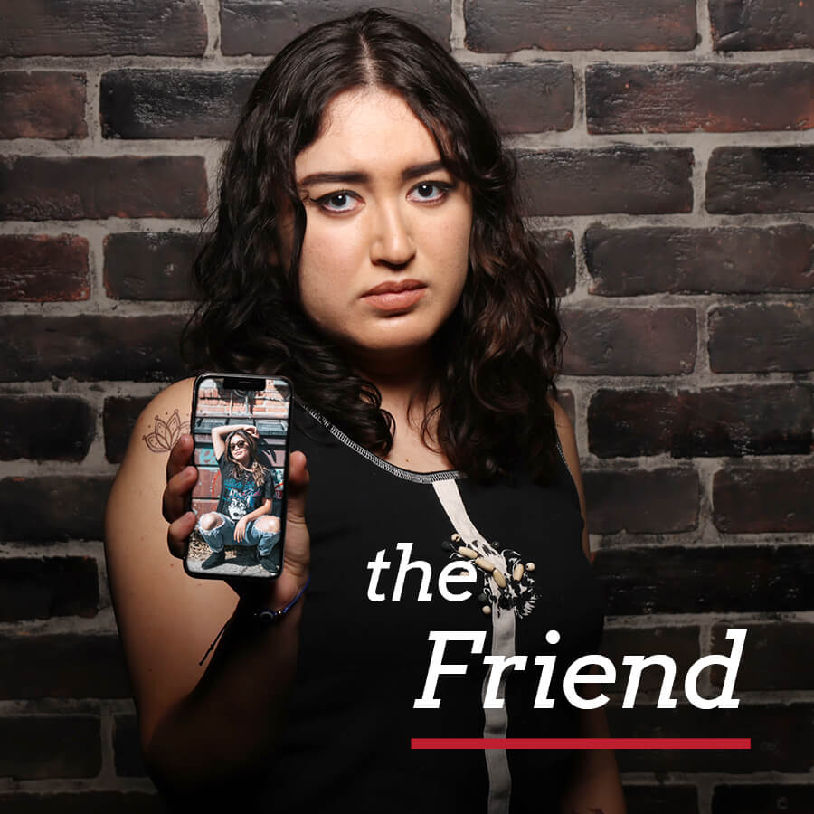 A young woman showing her phone with a picture of her friend on it