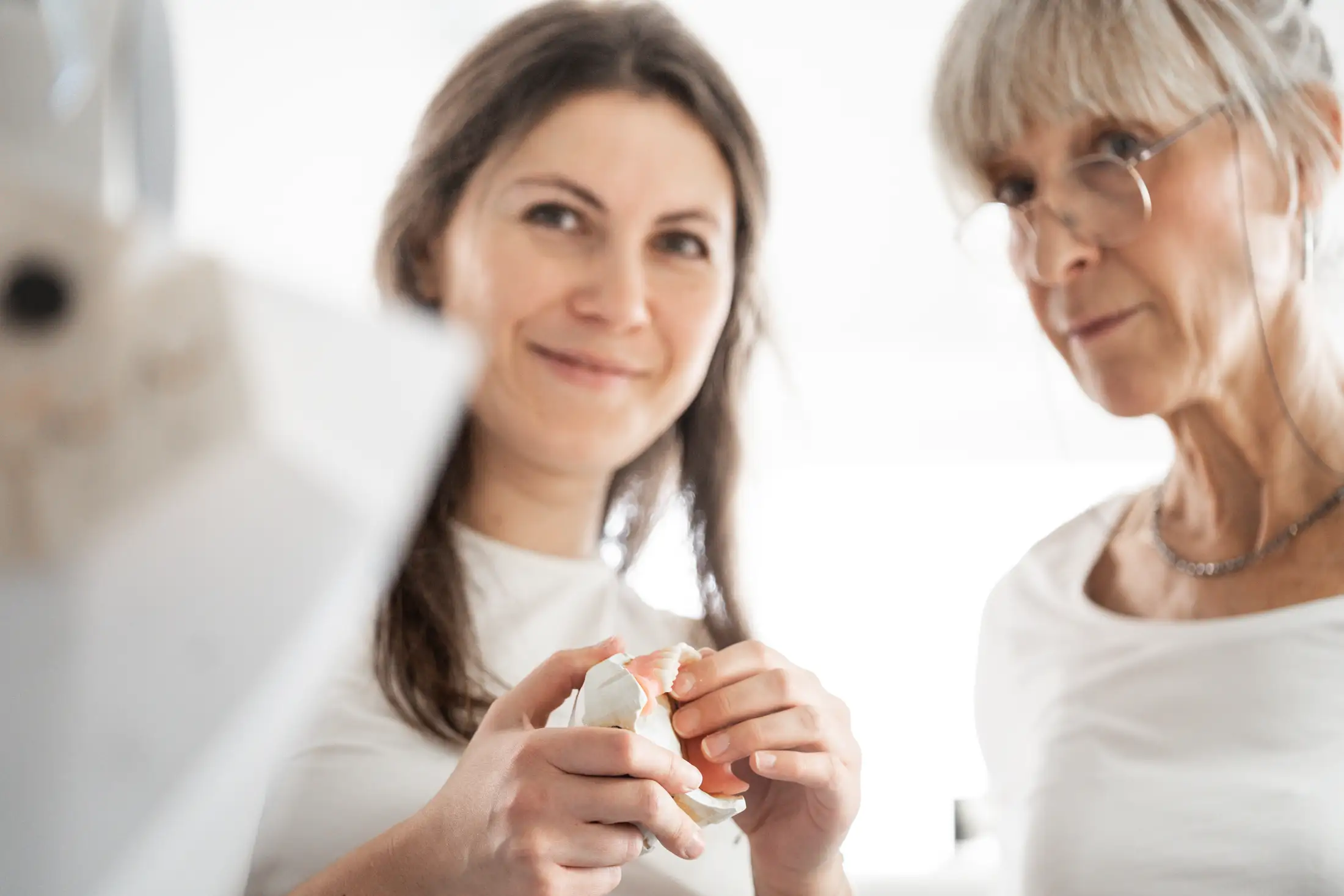 Zahnprothese wird von zwei Personen inspiziert