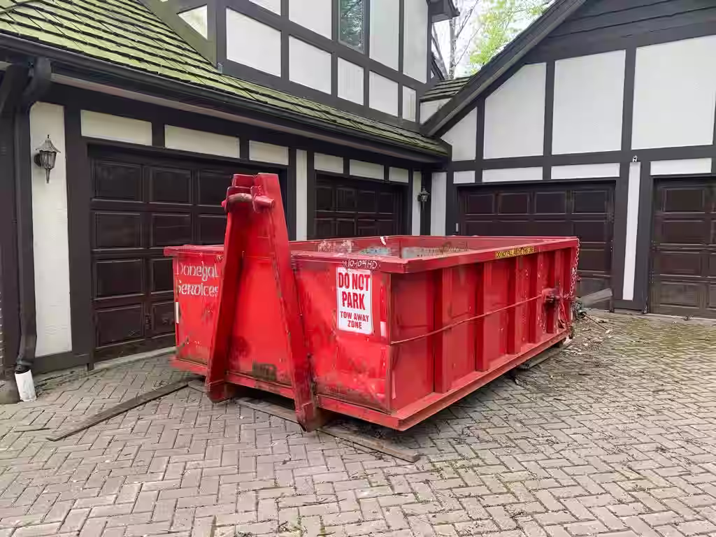 Donegal residential dumpster rental placed on a suburban Chicagoland driveway for home remodeling debris removal.