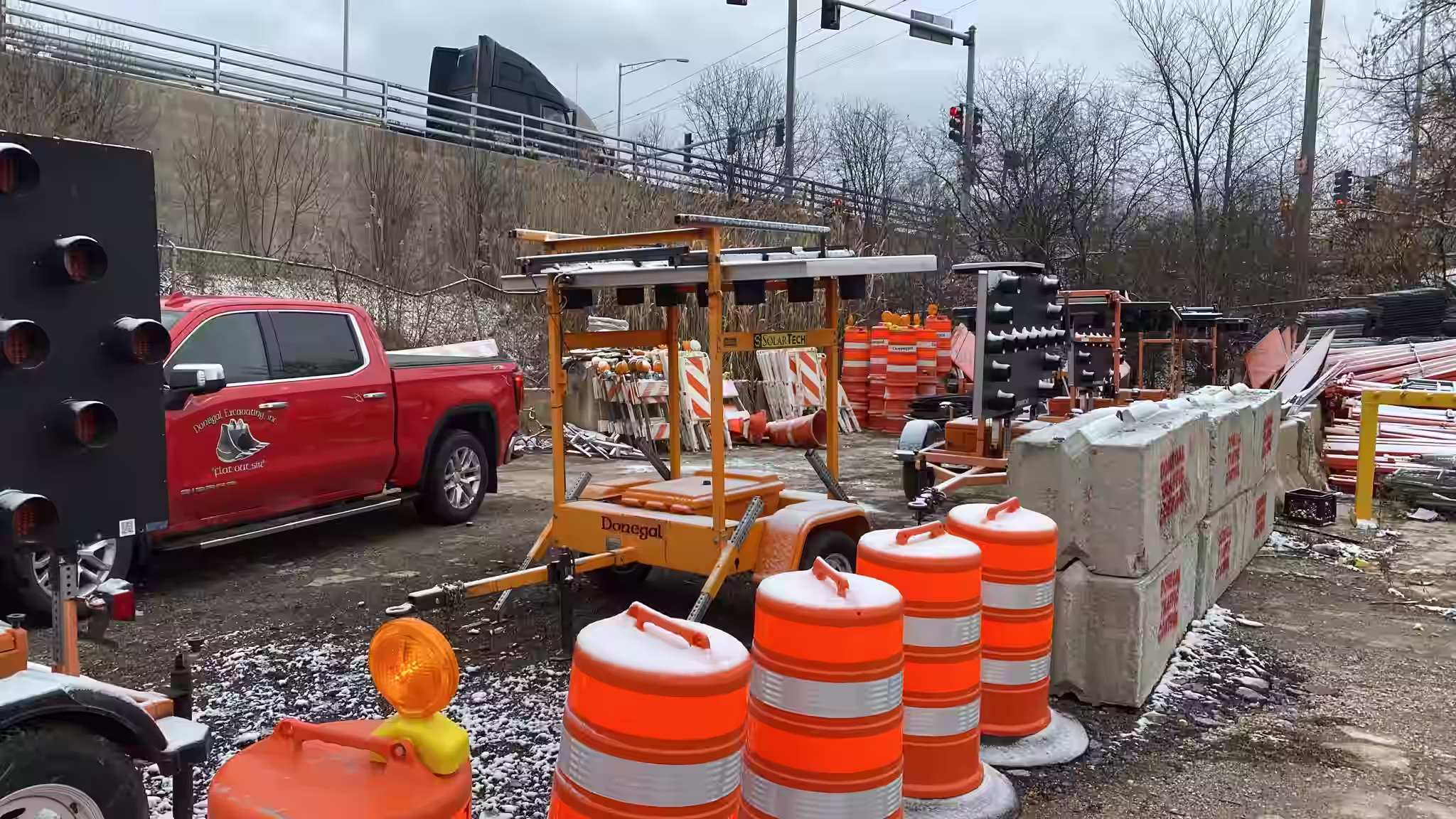 Collection of Donegal Services traffic control equipment including message boards, barricades, cones, and safety trailers.