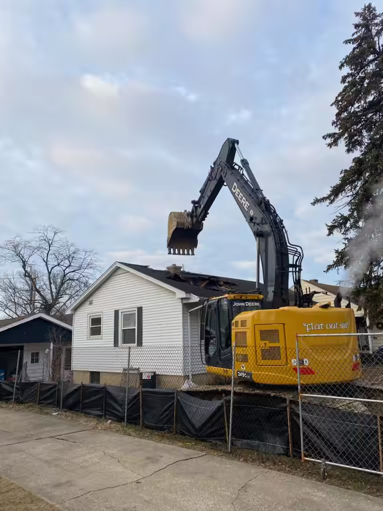Downers Grove home demolition by Donegal Services with an excavator removing roofing and structural components.