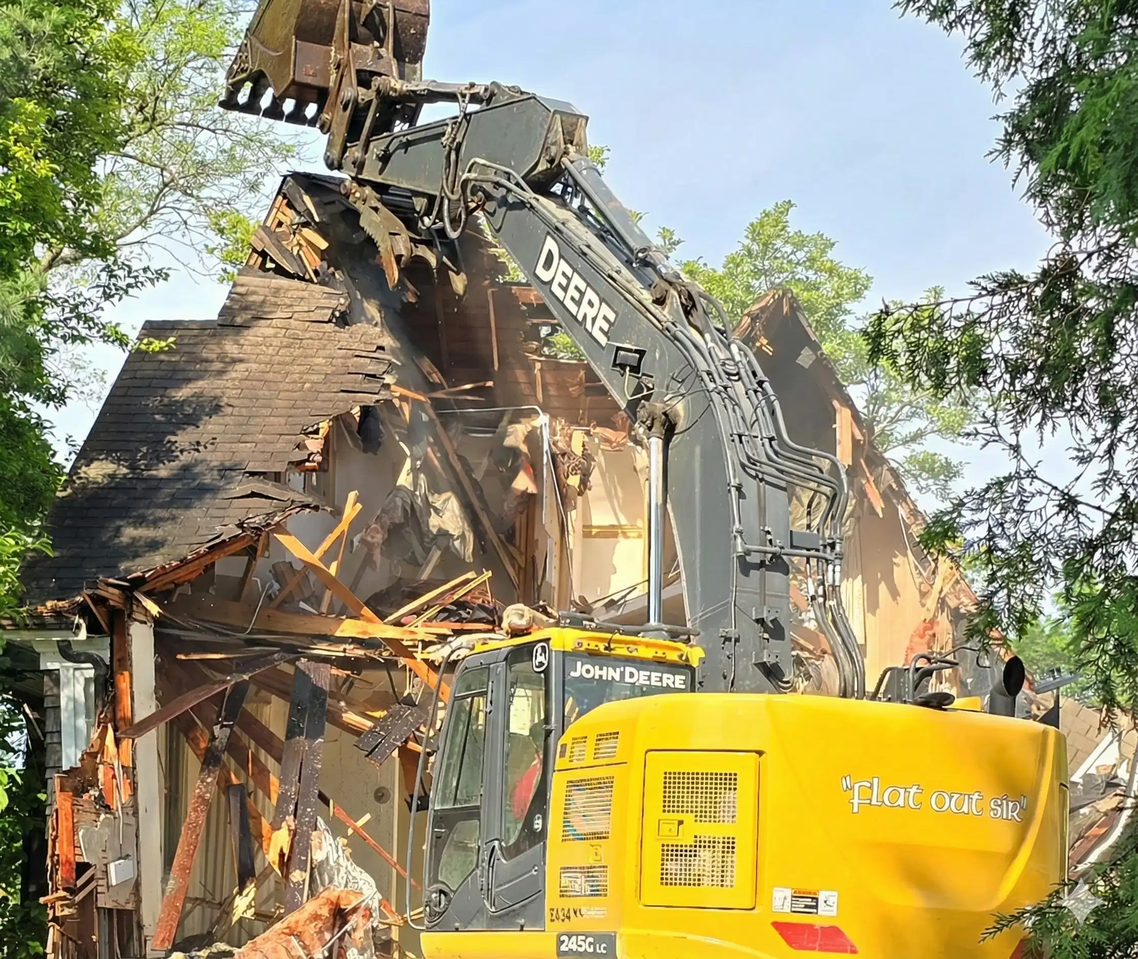 John Deere excavator performing residential demolition as Donegal Services tears down a home in Chicagoland.John Deere excavator performing residential demolition as Donegal Services tears down a home in Chicagoland.
