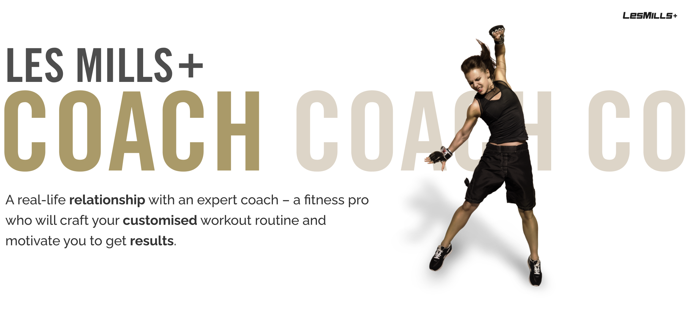 Energetic female fitness coach jumping with arm raised, promoting Les Mills+ Coach customized workout program.