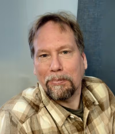 Johan - En läkare i ett porträttfoto med lugn bakgrund, som illustrerar den medicinska kompetens som finns på Vigilans Umeå AB för utredning och behandling av ADHD.