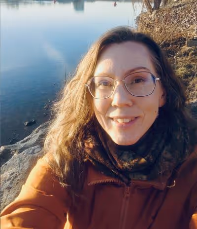 Ing-Marie - En vårdpersonal sitter utomhus vid vattnet i ett porträttfoto, i mjukt ljus och lugn miljö som speglar det trygga och professionella bemötandet inom ADHD-vården hos Vigilans Umeå AB.