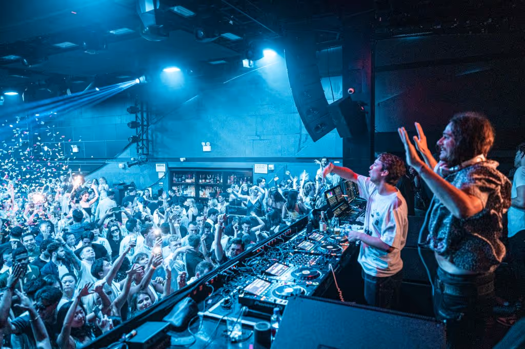 Crowd dancing under immersive lights at Nebula New York, a premier EDM and house music nightclub located in Times Square, NYC.