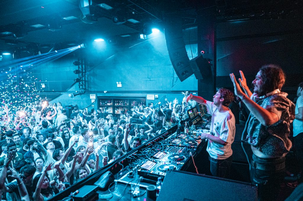 Crowd dancing under immersive lights at Nebula New York, a premier EDM and house music nightclub located in Times Square, NYC.
