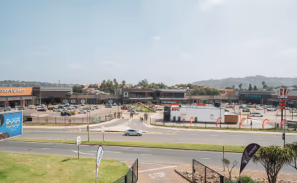 Corner view of Bassonia Shopping Centre building with multiple business signs including Absolute Pets and Curtain Club.