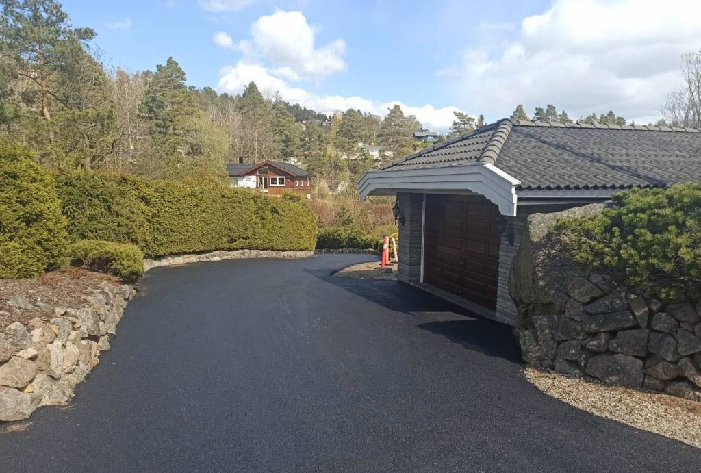 Asfaltert oppkjørsel foran en bolig