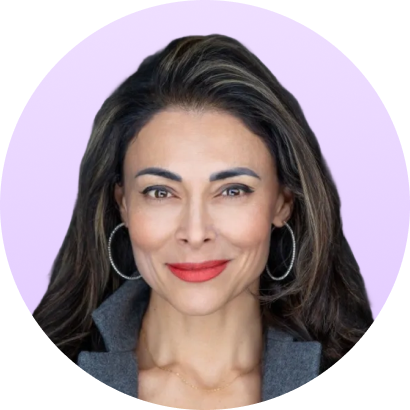 Portrait of a confident woman with long dark hair, hoop earrings, red lipstick, and a gray coat.