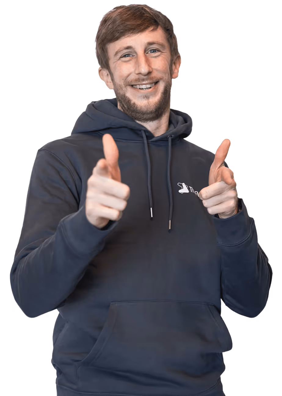 A professional portrait of a team member wearing branded apparel against a dark background, reflecting confidence, approachability, and company identity.