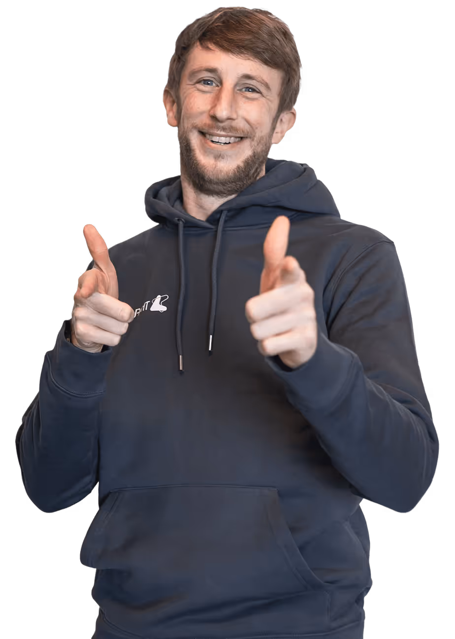 A professional portrait of a team member wearing branded apparel against a dark background, reflecting confidence, approachability, and company identity.