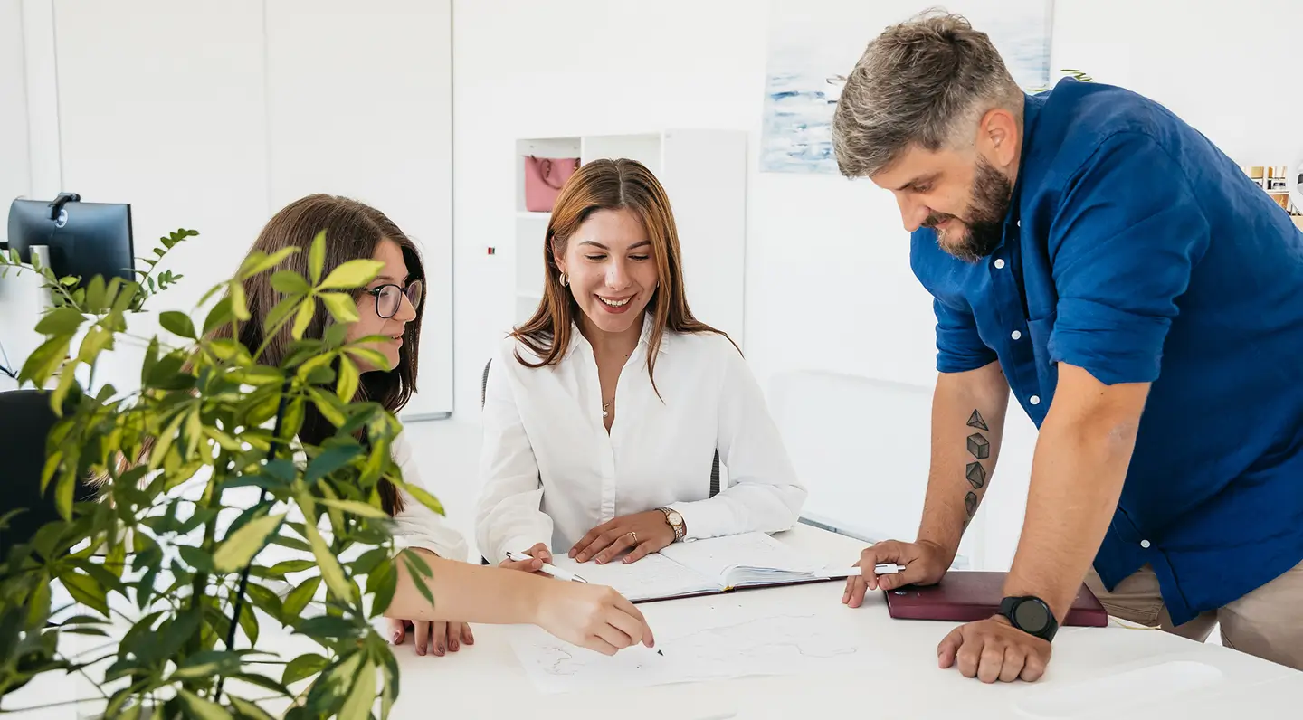 A group of Hidrocibalae offshore consultancy specialists collaborating on project plans and technical documentation in a bright office environment.