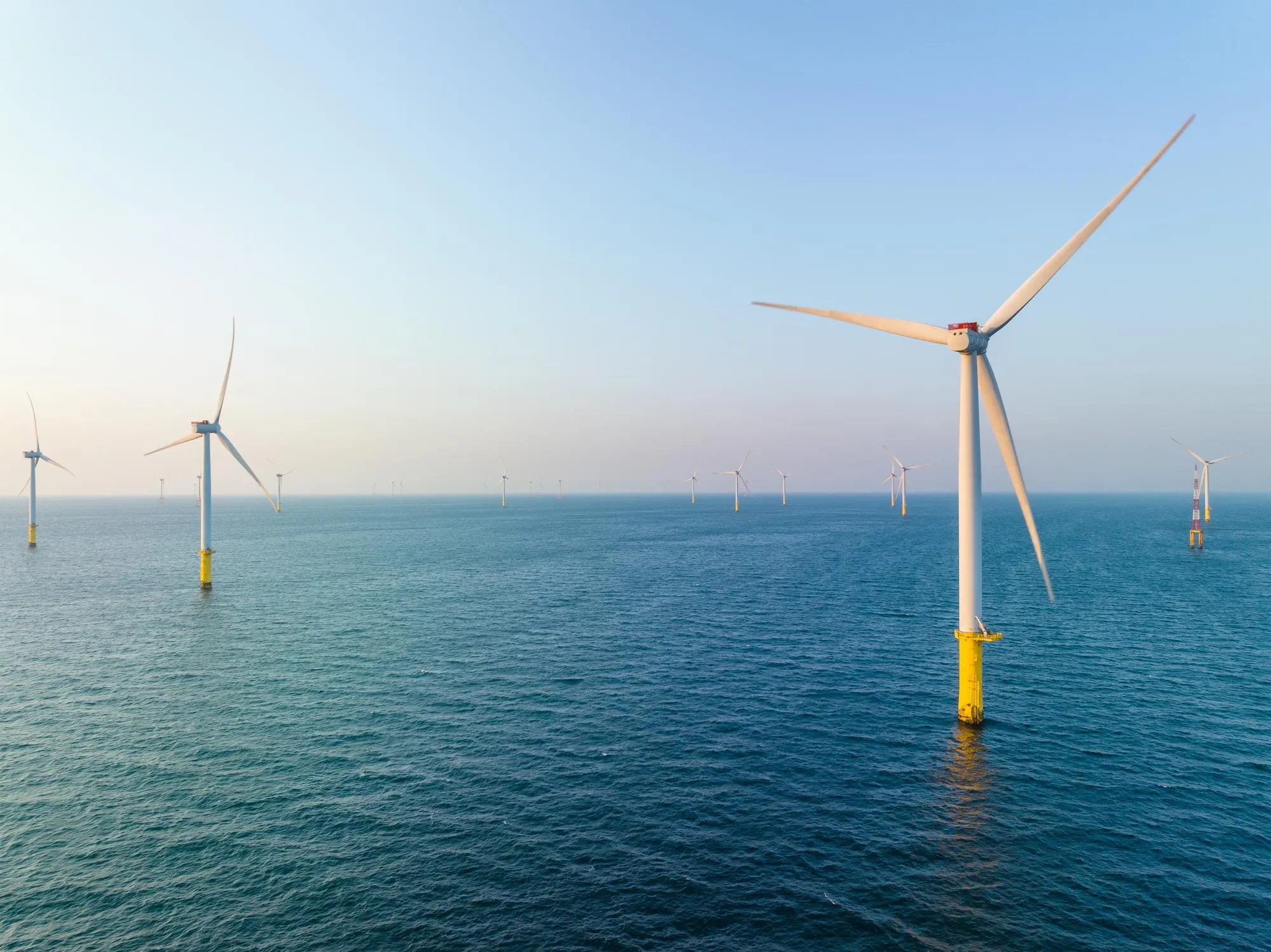 An offshore wind farm with marine wind turbines installed in the open sea, representing renewable energy site characterization and seabed surveys.