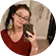 Smiling woman with glasses taking a mirror selfie with her smartphone.