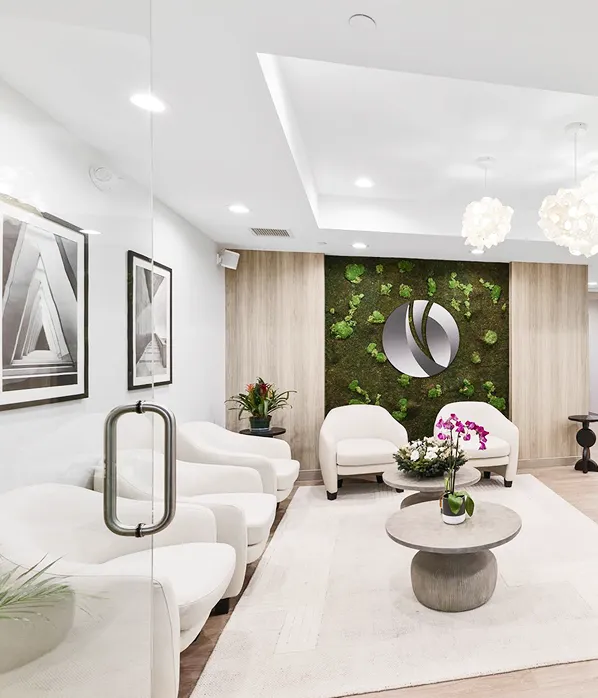 Modern dental office with black dental chair, equipped with overhead light, instruments, and a window showing outdoor greenery.