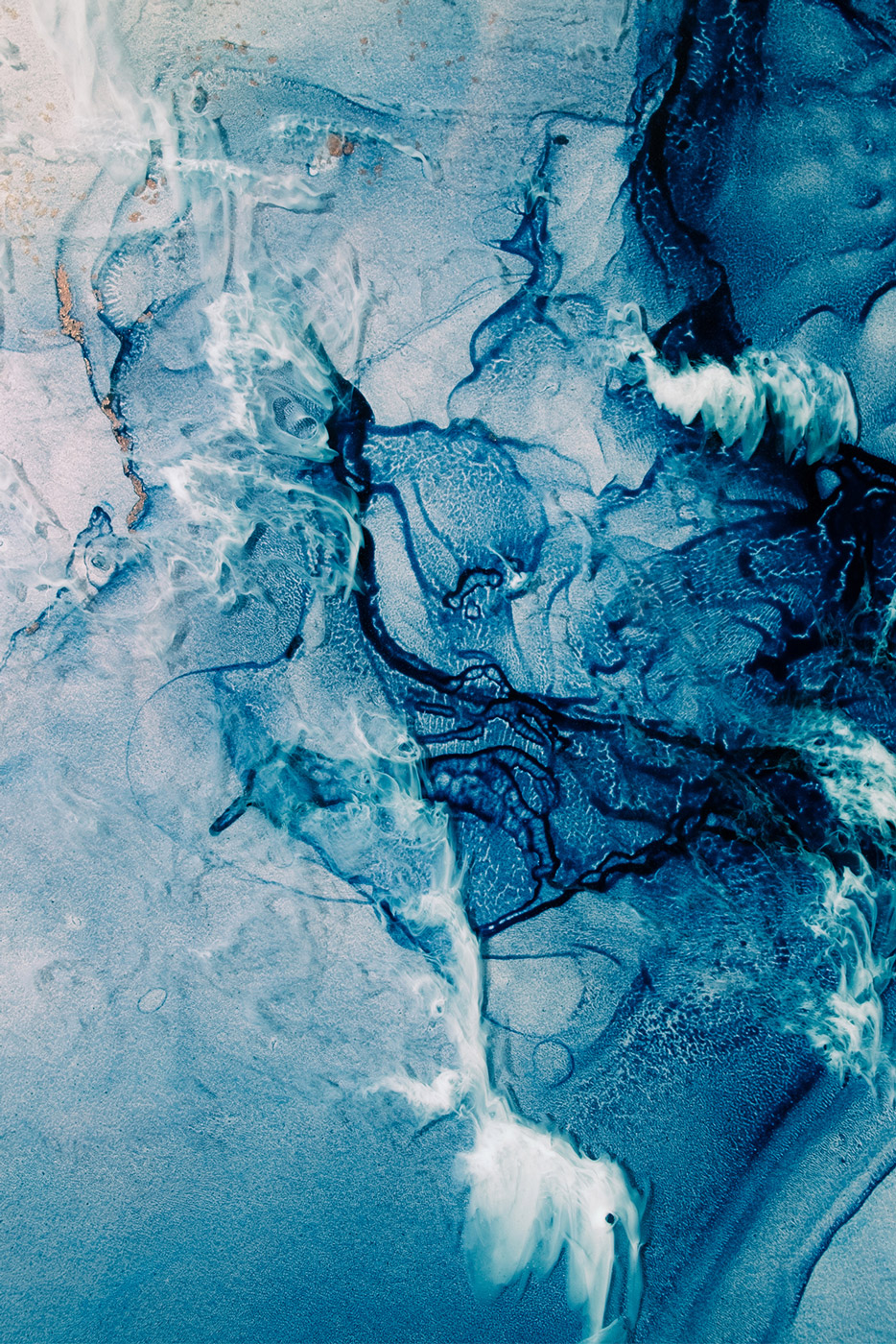 Abstrakt nærbilde av blå og hvite mønstre som ligner flytende blekk i vann.