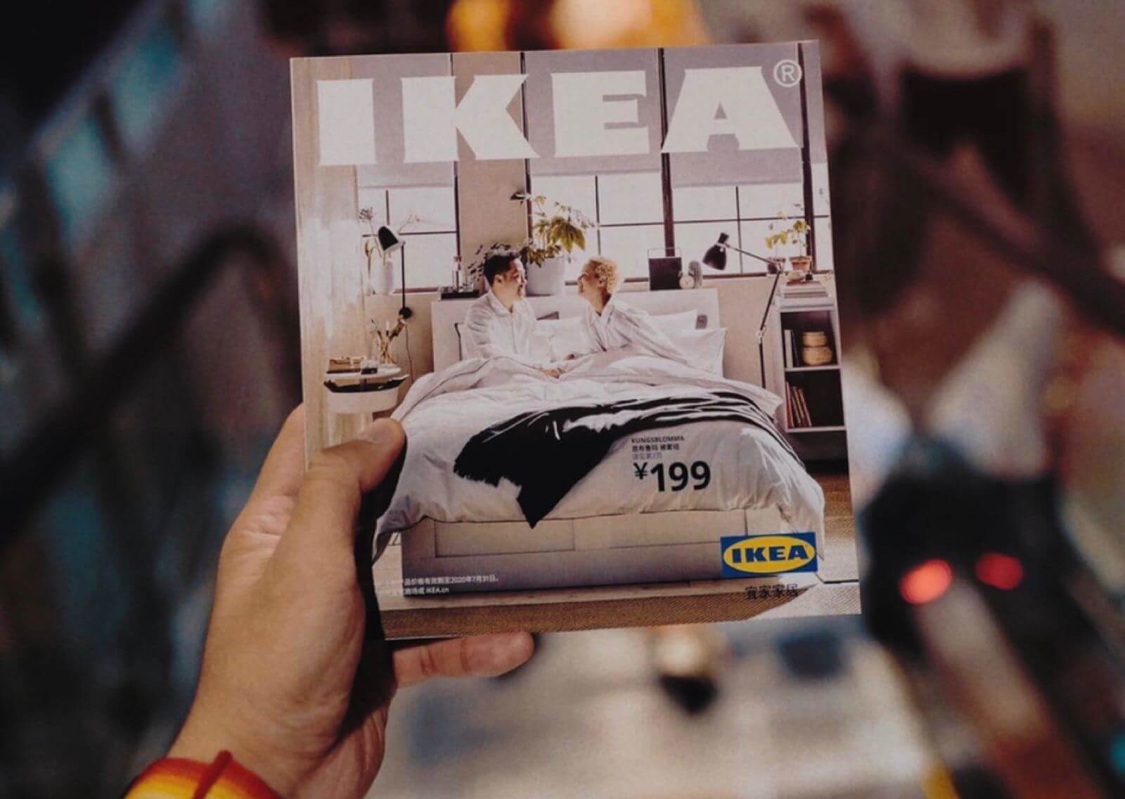 Person holding an IKEA magazine with their left hand