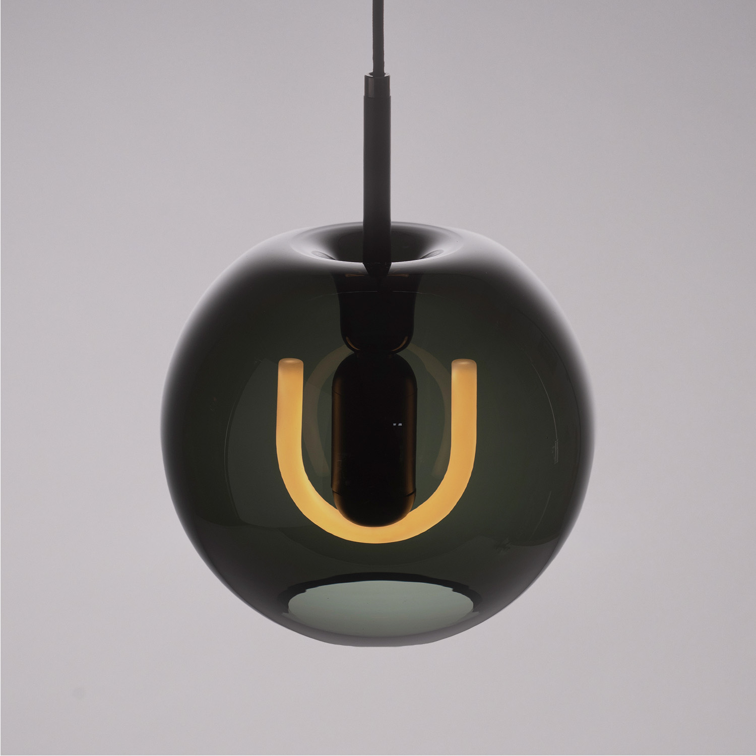 BEEM Toru smoke glass pendant with an illuminated U-shaped bulb.