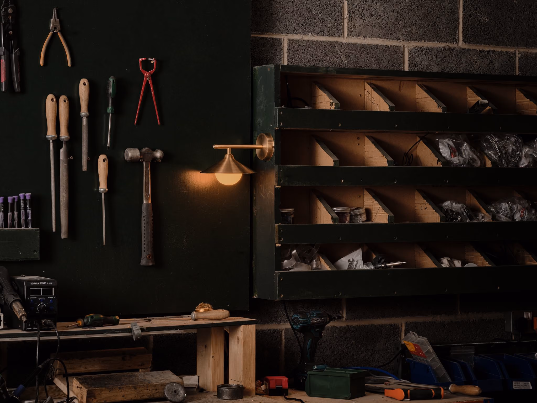 Glowing Mettle Edge wall light beside hand tools and timber shelves in a workshop.