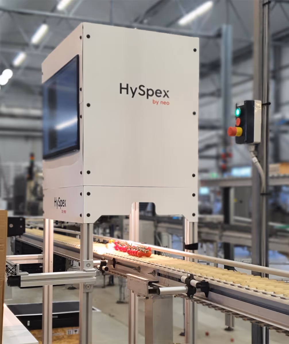 HySpex industrial machine inspecting items on a conveyor belt in a factory.