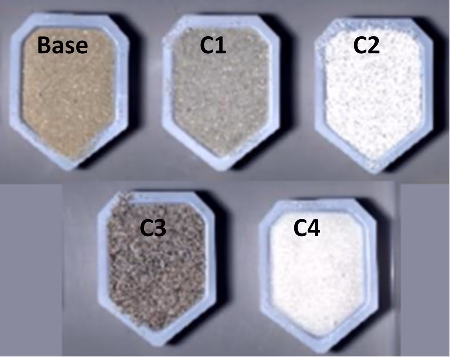 Five containers labeled Base, C1, C2, C3, and C4 filled with different shades of granular powders ranging from beige to white to gray.