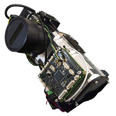 A HySpex Mjolnir OEM hyperspectral camera device with a circuit board, wiring, and cylindrical component mounted on a black and white frame.