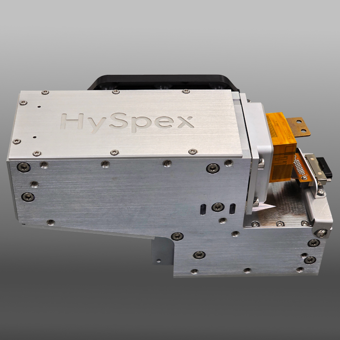 HySpex hyperspectral imaging camera in a metallic chassis with screws and an orange connector on a gray gradient background.