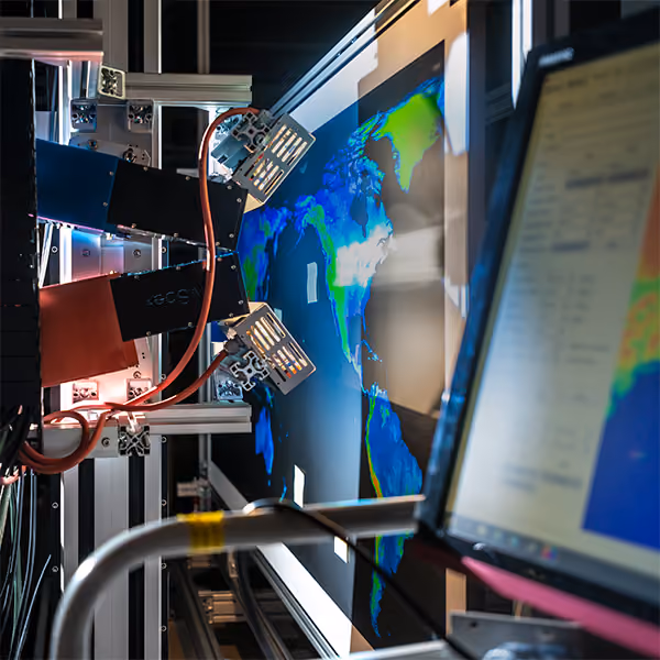 Hyperspectral imaging setup capturing a colorful Earth map displayed on a screen in a lab.