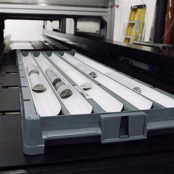A box of geological mineral cores on a scanning stage, going through a big hyperspectral scanning machine