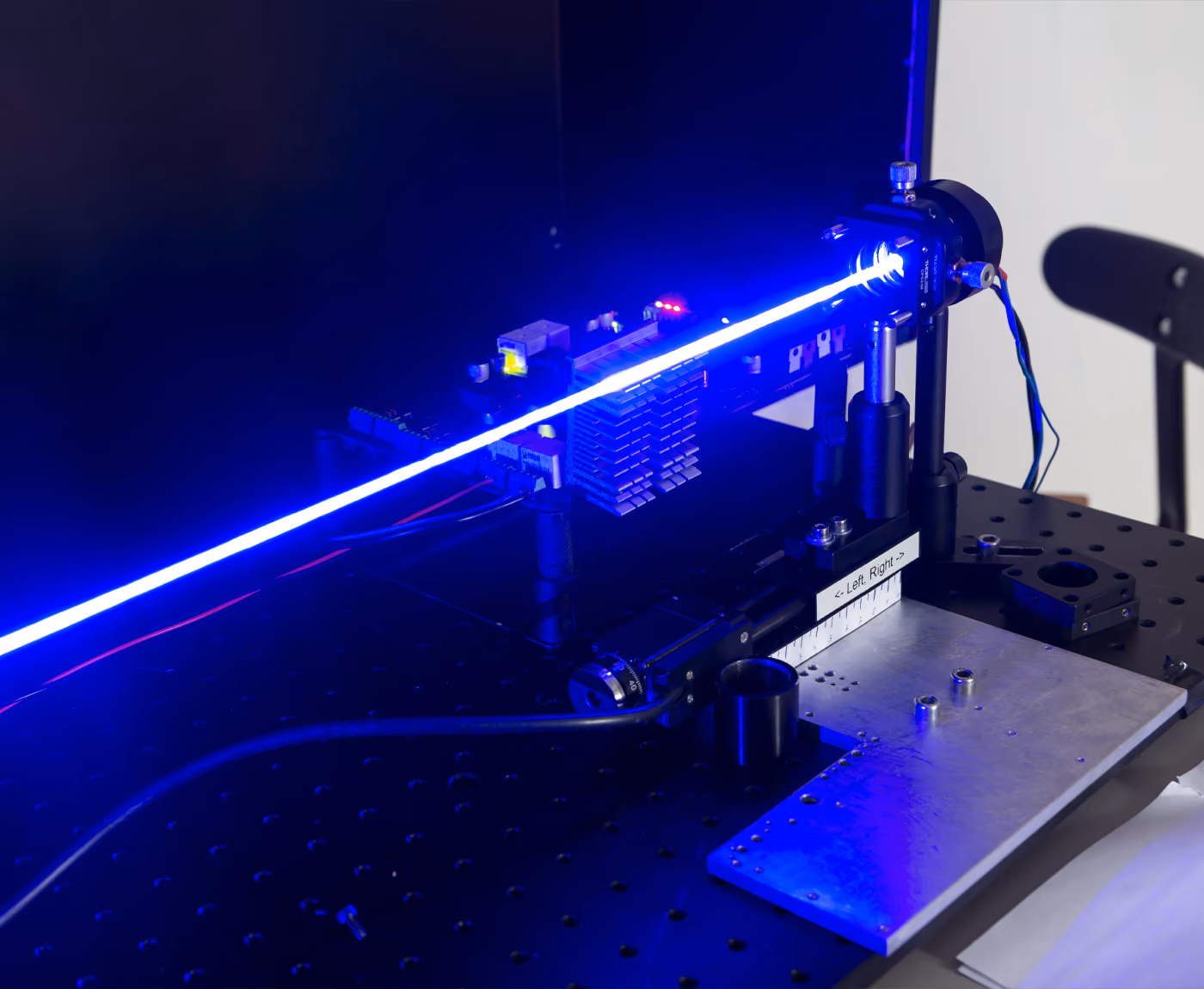 A device emitting a blue laser in a dimly lit room