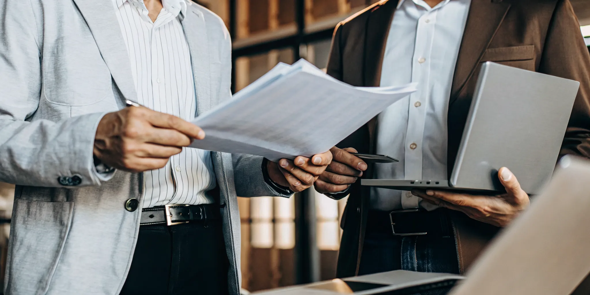 Landlords screening a Section 8 tenant application with a laptop and paperwork.