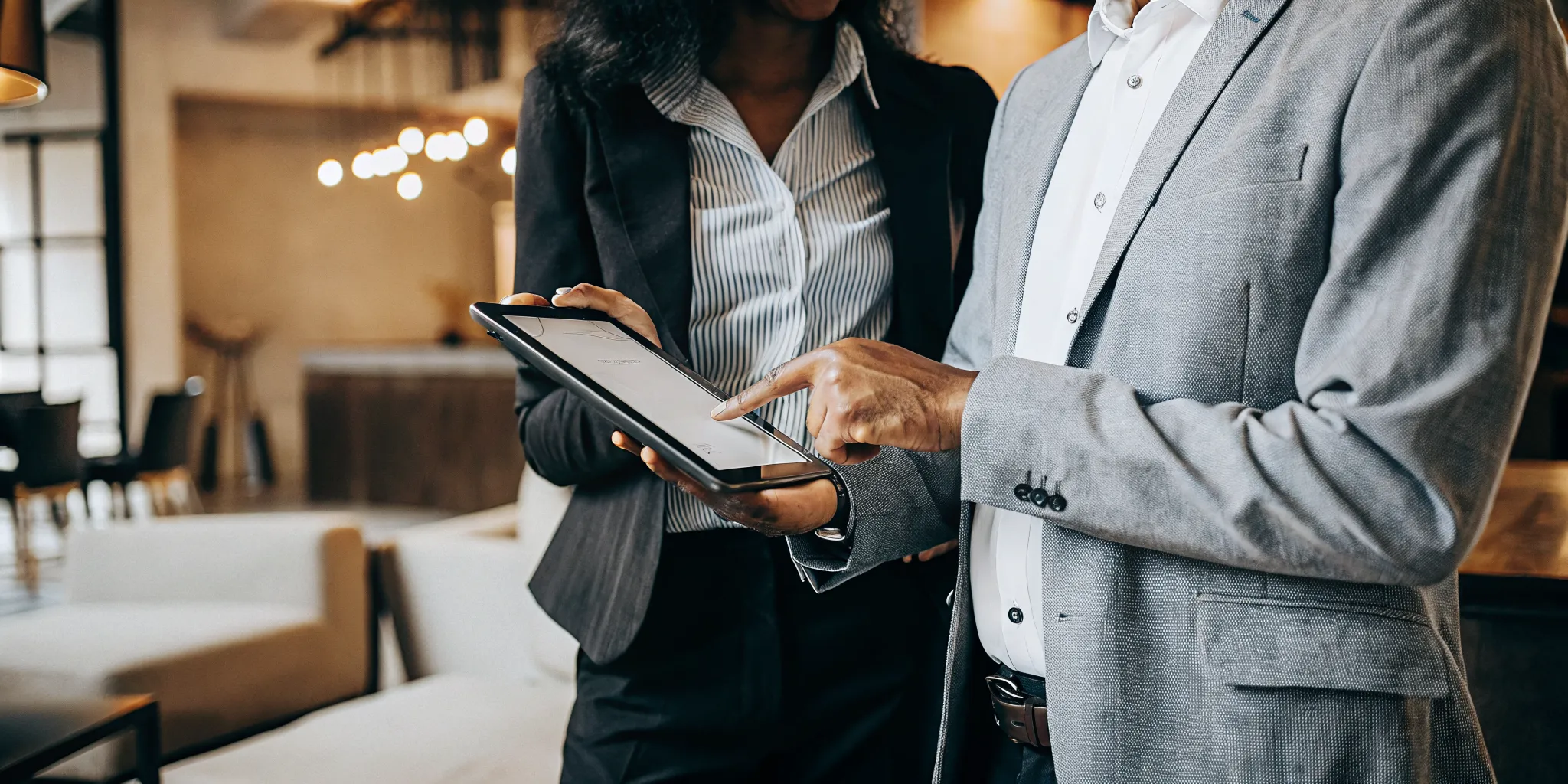 Professional property manager and prospective tenant reviewing a portable tenant screening report in a Colorado rental office