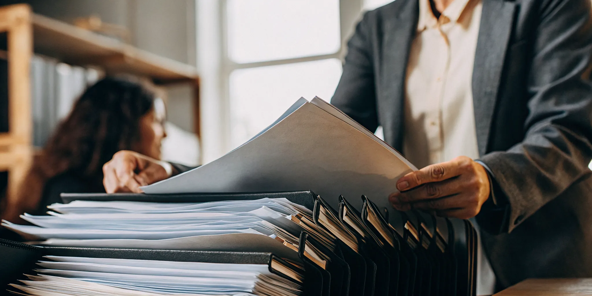 Property manager reviewing rental applications organized by state at a desk