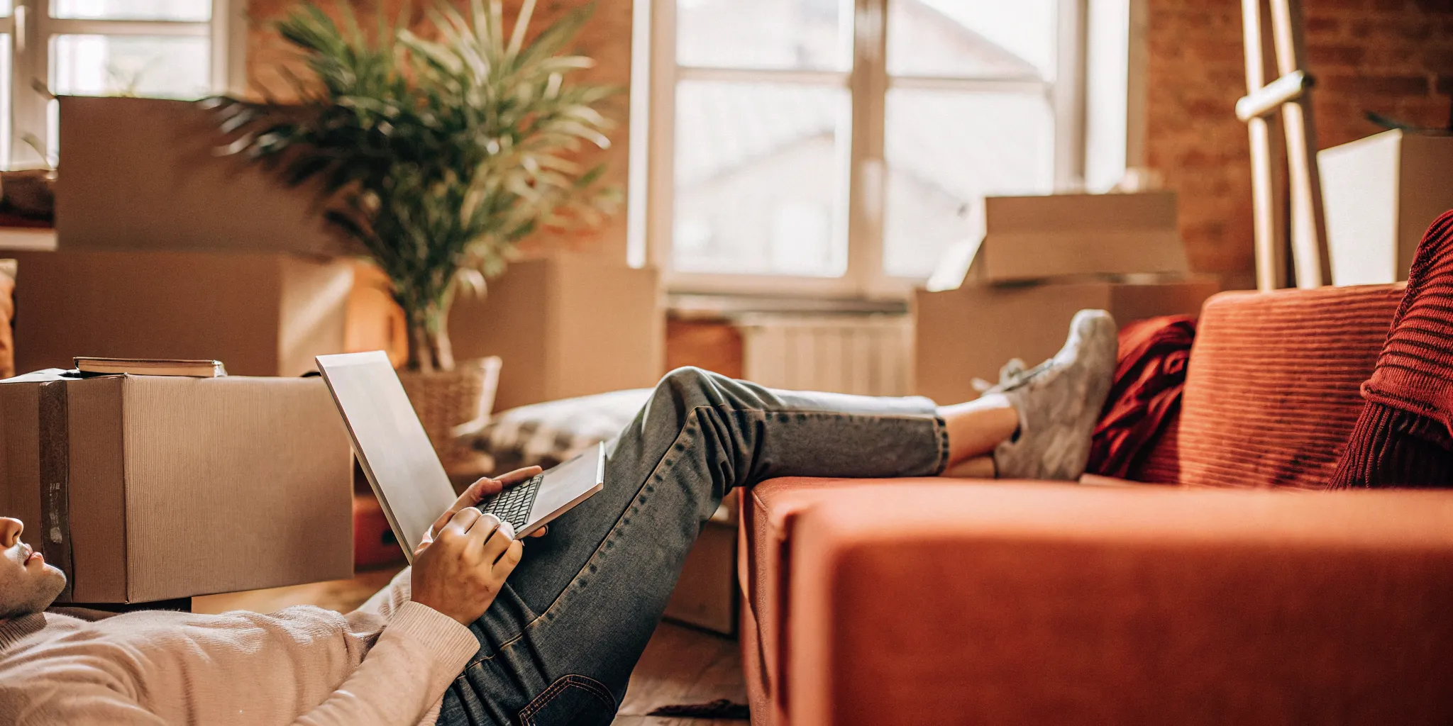 Renter reviewing rental options on a laptop in a bright apartment