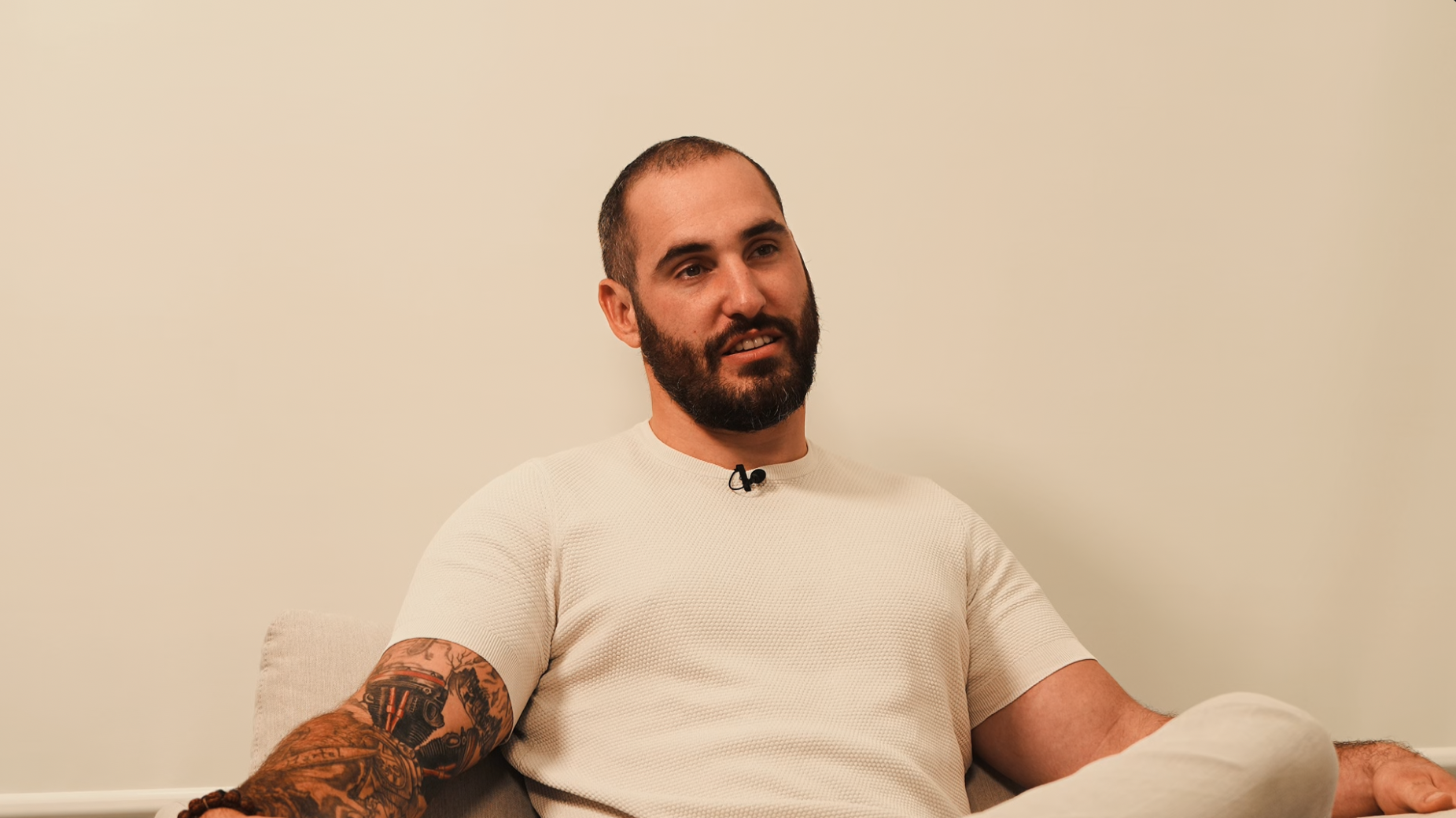 A close-up of a modern architectural staircase with curved railings and beige concrete, against a clear blue sky.