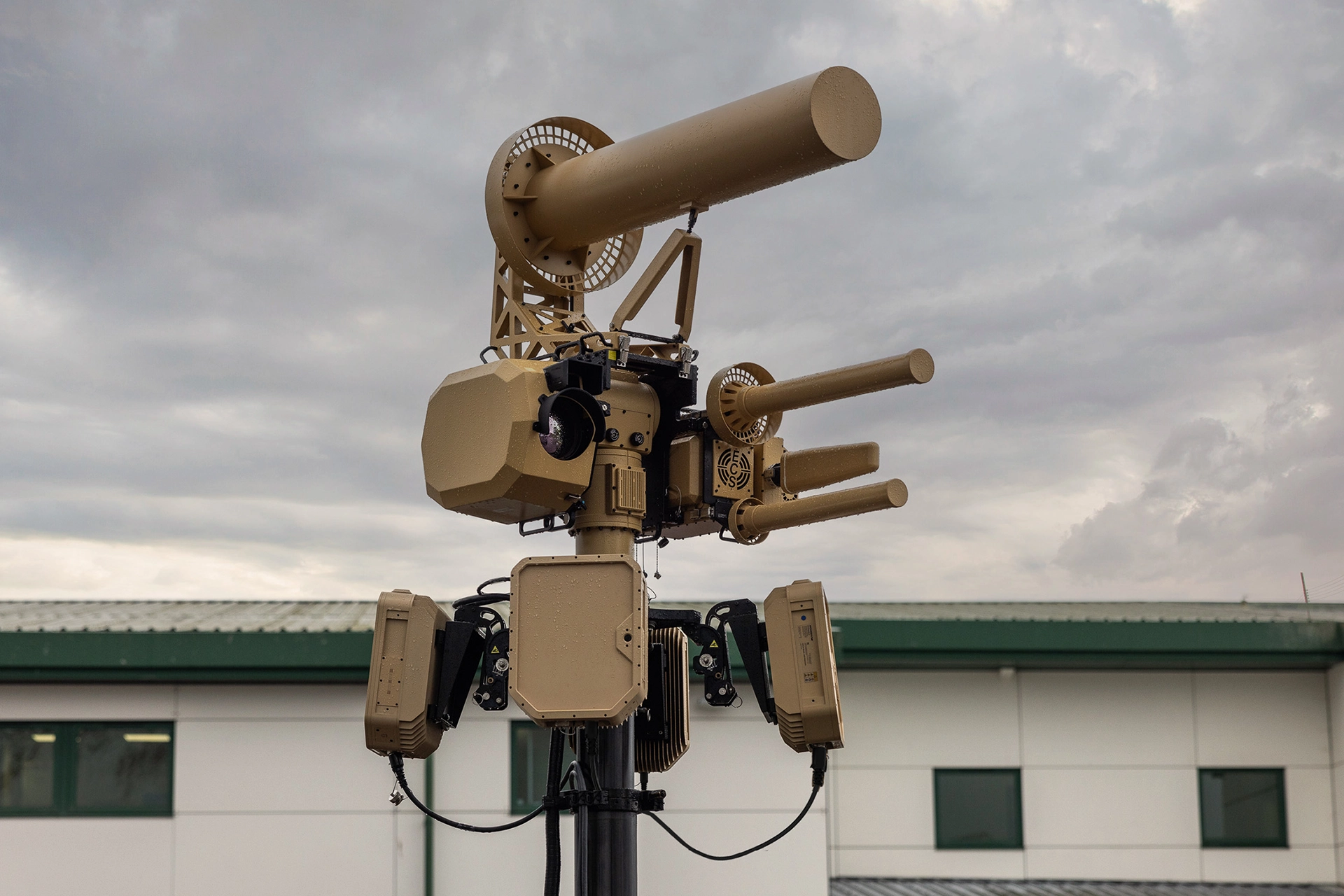 Close-up of a tan EchoShield sensor tower with cloudy sky in the background