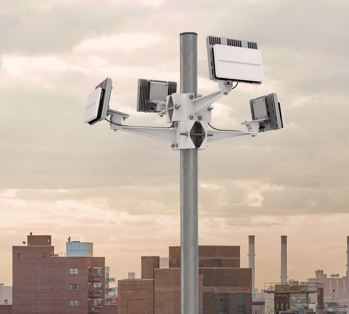 Metal pole with four mounted white EchoGuard devices against a city skyline with cloudy sky.