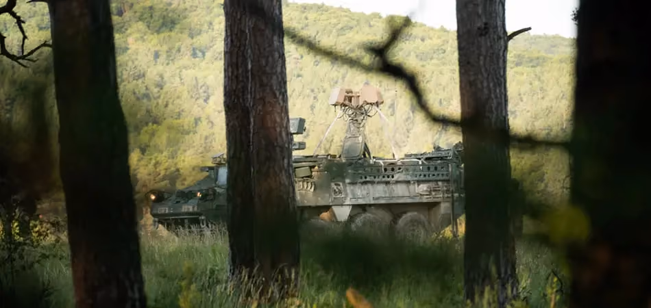 Grey vehicle with mounted EchoShield radars against a black background with grey hexagon pattern