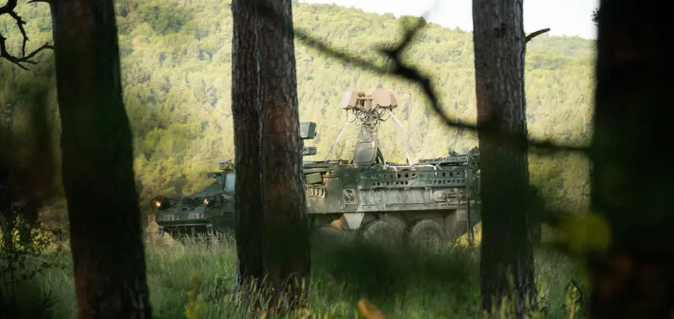 Grey vehicle with mounted EchoShield radars against a black background with grey hexagon pattern